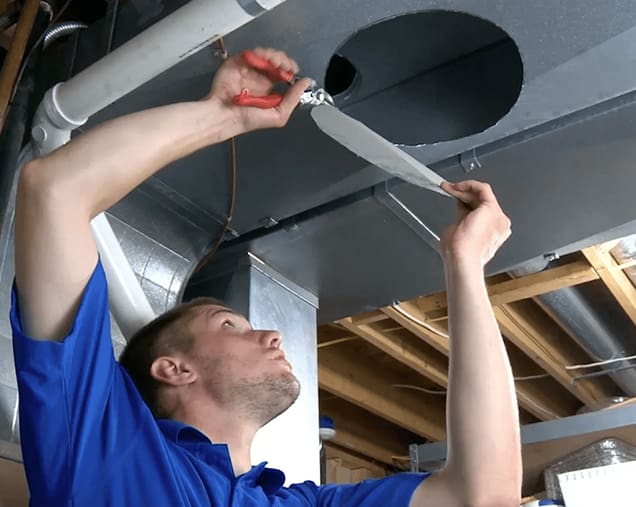 A man working on the ceiling of an unfinished room.