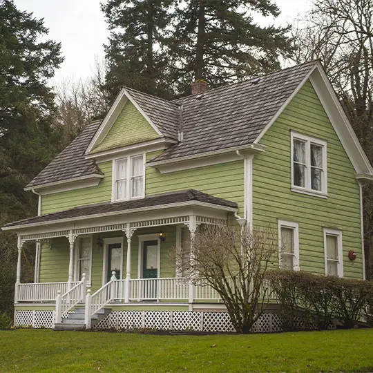 A green house with white trim and a porch.